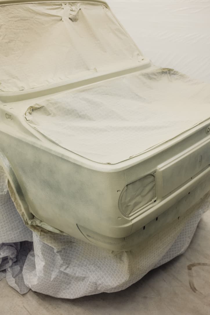BMW 2002 body in primer stage with masked areas in paint booth